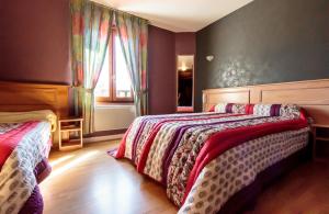a bedroom with two beds and a window at Maison Legate "Hôtel Le Baudiere & Spa" in Saint-Beauzire +57 photos