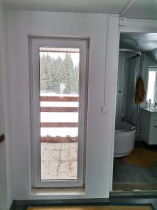 a bathroom with a window with a view of a tub at Căsuța de munte in Mărişel