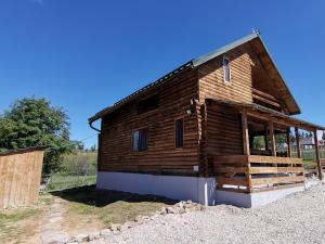 a log cabin with a large window at Căsuța de munte in Mărişel