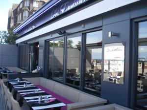 a restaurant with tables and chairs in a building at Les Embruns in Trouville-sur-Mer
