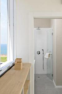 a white bathroom with a shower and a window at Stylish & Spacious 3 bedroom apartment by the Sea in Netanya