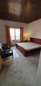a bedroom with a large bed and a large window at Stairway to Heaven in Murree