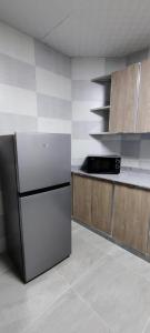 a kitchen with a refrigerator and a counter top at AL NOOR SUITES in Salalah +9 photos