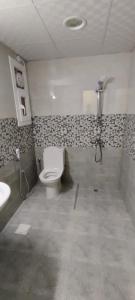 y baño con aseo y lavamanos. en AL NOOR SUITES, en Salalah