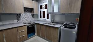 a kitchen with a sink and a stove top oven at AL NOOR SUITES in Salalah