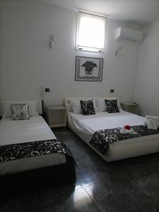 een slaapkamer met 2 bedden en een raam bij B&B Villa Esmeralda in San Filippo del Mela