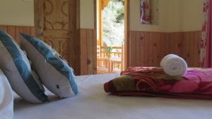 um quarto com uma cama com almofadas em MOZO Inn&Cafe Jibhi em Banjār