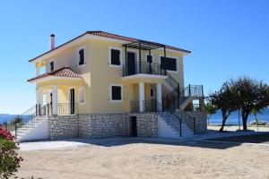 a large yellow house on the beach at CASA DEL MARE in Lixouri