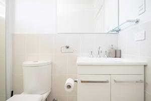 ein weißes Badezimmer mit Toilette und Waschbecken in der Unterkunft Adorable 1-bedroom Kuzman Guesthouse in Mudgee