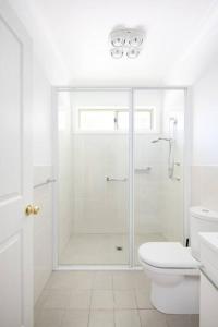 ein weißes Badezimmer mit Dusche und Toilette in der Unterkunft Adorable 1-bedroom Kuzman Guesthouse in Mudgee