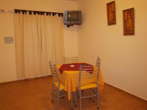 uma sala de jantar com uma mesa com cadeiras e uma televisão em Apart C&C Jáchal em San José de Jáchal