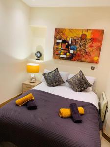 Executive Central Apartment في سندرلاند: غرفة نوم بسرير ومخدات صفراء ولوحة
