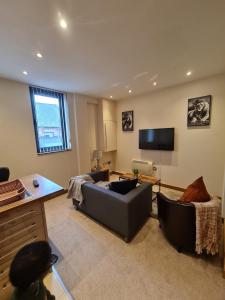 een woonkamer met een bank en een flatscreen-tv bij Executive Central Apartment in Sunderland