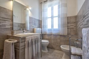 łazienka z umywalką, toaletą i lustrem w obiekcie Casa Vacanza da Albino w mieście Sorso +29 zdjęć