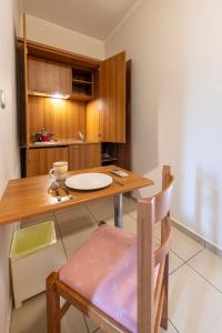une cuisine avec une table en bois et une chaise dans l'établissement J Studios - Kineta Seaside Retreats, à Kinetta