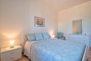 a bedroom with a blue bed with two lamps and a dresser at Casa Vacanza da Albino in Sorso