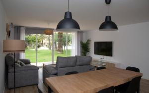 a living room with a dining room table and chairs at Jamaica Beach House in Puebla de Farnals