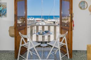 a table and chairs on a balcony with a marina at Brezza Marina Apartment in San Vincenzo