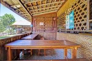 a restaurant with wooden tables in the back of it at OYO Life 91201 Larasati Homestay Pantai Klayar in Pacitan