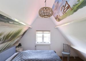 una camera mansardata con letto e finestra di Idyllisch en knus huisje met prachtige veranda. a Oterleek