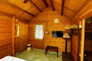 um quarto de madeira com uma televisão e uma mesa em Resort Primo Bom Terra Verde em Baga
