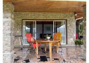 einen Holztisch und Stühle auf einer Terrasse in der Unterkunft Anse Soleil Resort in Baie Lazare, Insel Mahé