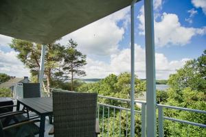 a view from the porch of a house with a table and chairs at moderne Ferienwohnung mit Balkon, Meerblick - Ferienresidenz Zwei BoddenFeWo 1-3 in Lietzow +13 photos