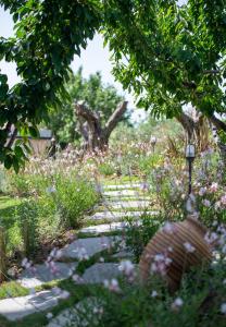 a garden with flowers and a stone path at Antigoni Seaside Resort in Ormos Panagias