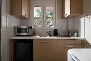 a kitchen with a microwave and a sink at Antigoni Seaside Resort in Ormos Panagias
