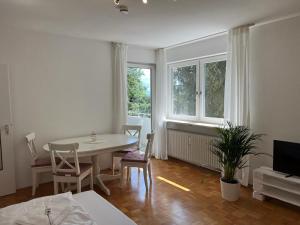 a living room with a table and chairs and a window at Ferienwohnungen Sisi in Pöcking