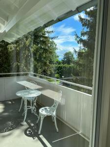 a balcony with a table and two chairs and a window at Ferienwohnungen Sisi in Pöcking +7 photos