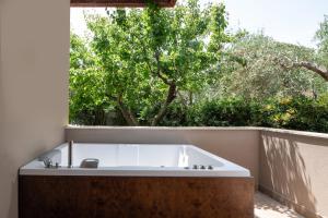 a bath tub sitting in front of a window at Antigoni Seaside Resort in Ormos Panagias