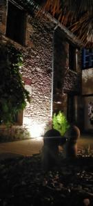 a brick building with a stone wall with a light at La cour des Ursulines in Josselin