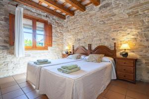 a bedroom with a bed in a stone wall at El Clos 2 in Conesa