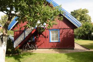 a red house with a bike parked in front of it at Fisherman´s House in Nida