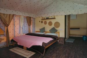 a bedroom with a large bed in a tent at Crazy Cub Camp in Bīr