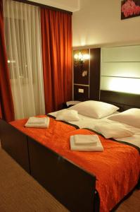 una camera d'albergo con due letti e asciugamani di Hotel Junior 2 a Cracovia