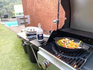 a pan of food is cooking on a grill at VILLA COLINA Cannes Mandelieu in Mandelieu-La Napoule