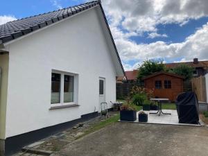 una casa blanca con una mesa de picnic al lado en Ferienhaus Stralsundia en Stralsund