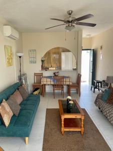 salon z zieloną kanapą i stołem w obiekcie Ikaria Village Apt 201 w Pafos