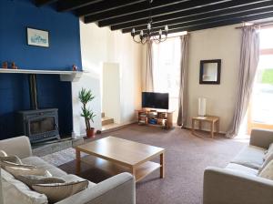 a living room with a couch and a coffee table at La Petellerie, maison de campagne avec piscine pour un séjour détente in Moyon