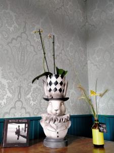 a vase with a top hat on a table at La cour des Ursulines in Josselin