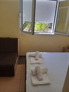 a room with two towels on a bed with a window at Vila Branka in Čanj
