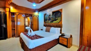 a bedroom with a large bed and a night stand at Auckland Hotel and Restaurant Near Mall Road in Shimla