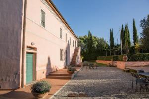 a building with a door and a staircase next to it at Agriturismo Gli Archi in Fauglia