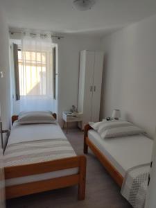 聖內德爾賈的住宿－Apartment Zagalo，一间卧室设有两张床和窗户。