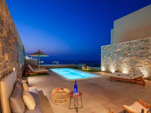 a villa with a swimming pool at night at Ligaria Mare in Agia Pelagia