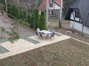 a patio with a table and chairs in a yard at Apartman 67 in Divčibare