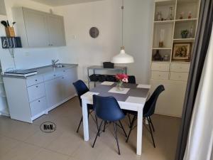 a kitchen with a table and chairs in a room at N&N Apartments and Rooms by Locap Group in Portorož