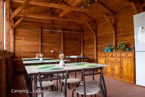 a kitchen with wooden walls and tables and a refrigerator at "La Aurel" Mahmudia in Mahmudia